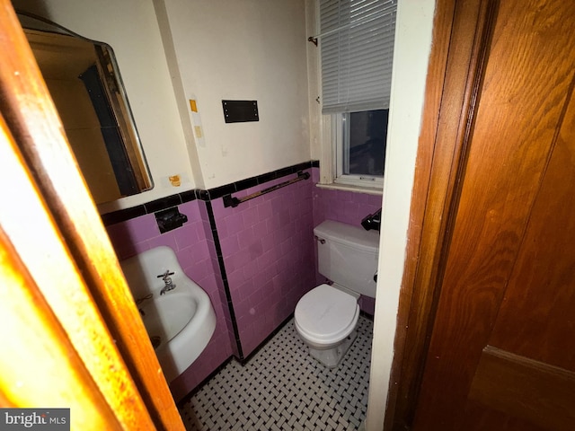 bathroom featuring toilet and tile walls