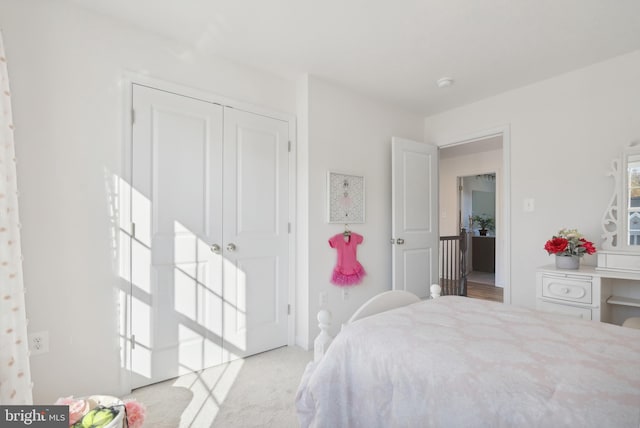 bedroom featuring a closet and light colored carpet