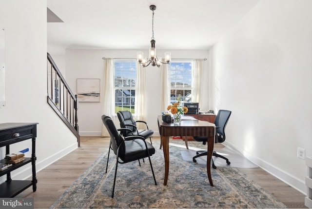 office space featuring wood-type flooring and an inviting chandelier