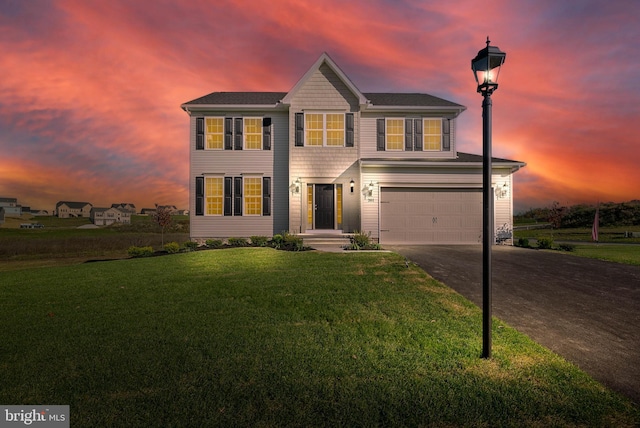 colonial home with a lawn and a garage