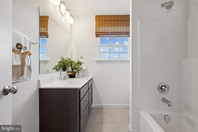 bathroom featuring tile patterned floors, vanity, a healthy amount of sunlight, and washtub / shower combination