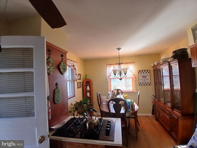 dining room with hardwood / wood-style flooring and an inviting chandelier