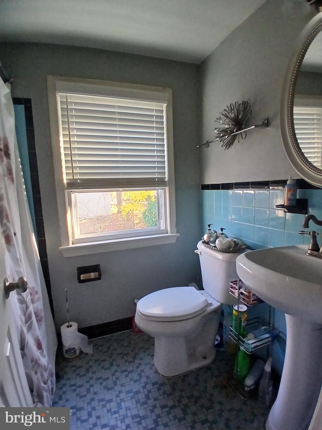 bathroom with decorative backsplash and toilet