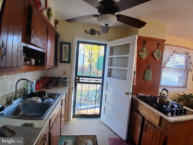 kitchen featuring decorative backsplash, sink, and ceiling fan