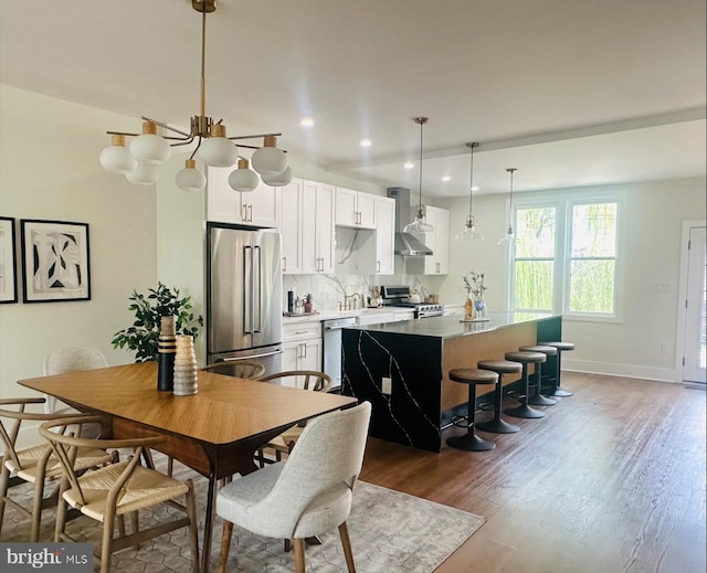 dining area with a notable chandelier and dark hardwood / wood-style flooring