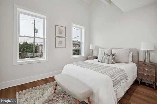 bedroom featuring dark hardwood / wood-style flooring, multiple windows, and lofted ceiling