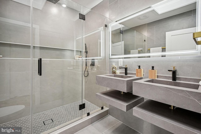 bathroom featuring tile patterned floors, tile walls, vanity, and an enclosed shower