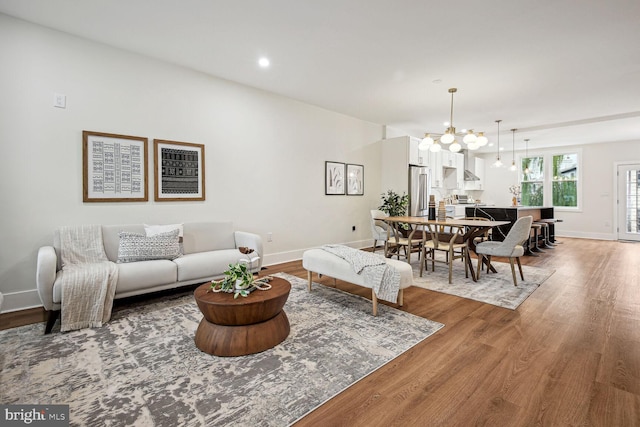 living room featuring wood-type flooring and an inviting chandelier