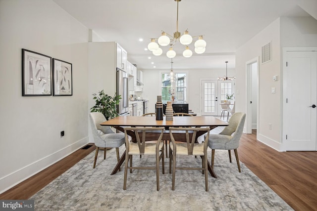 dining room featuring french doors, light hardwood / wood-style flooring, and an inviting chandelier