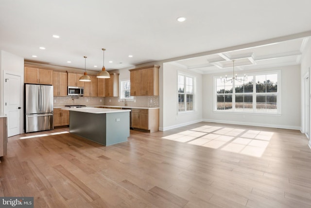 kitchen with appliances with stainless steel finishes, a center island, backsplash, and decorative light fixtures