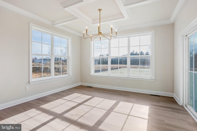 unfurnished dining area featuring coffered ceiling, an inviting chandelier, crown molding, light wood-type flooring, and beam ceiling