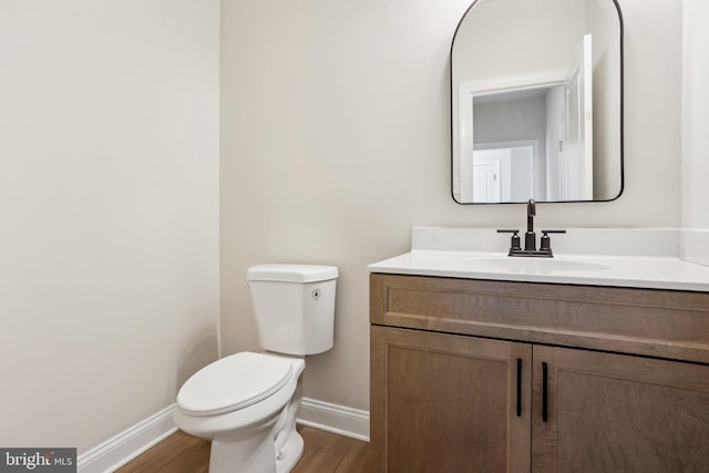 bathroom with vanity, wood-type flooring, and toilet