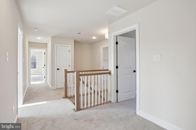 hall with light colored carpet