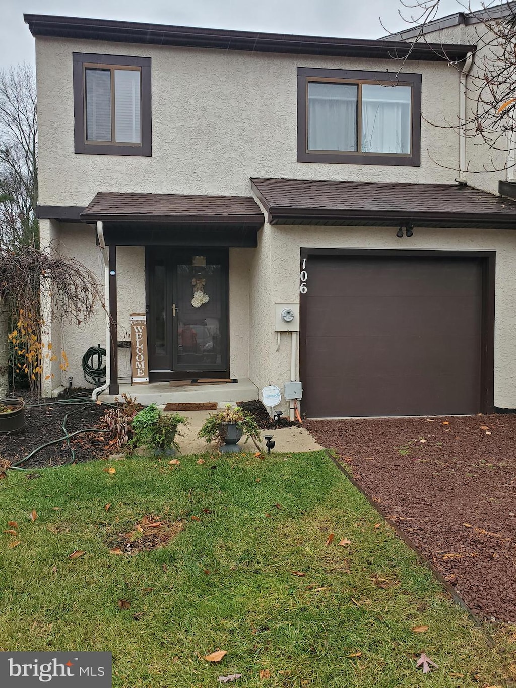 view of front of property featuring a garage and a front lawn