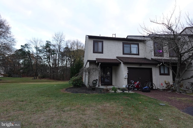 rear view of house with a lawn and a garage