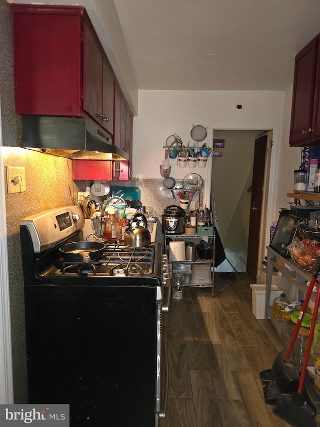 kitchen with stainless steel range and dark hardwood / wood-style flooring