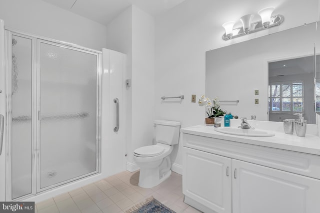 bathroom with tile patterned floors, vanity, toilet, and a shower with shower door