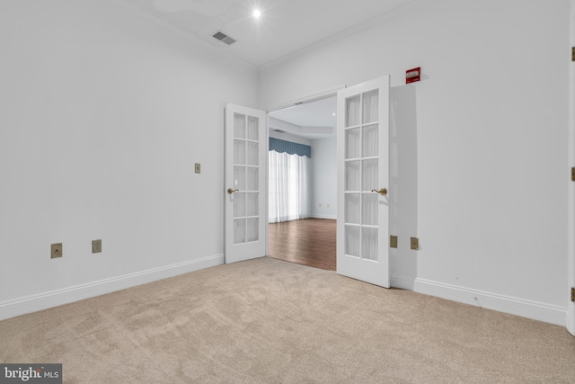 spare room with crown molding, light colored carpet, and french doors