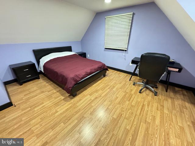 bedroom with light hardwood / wood-style flooring and lofted ceiling