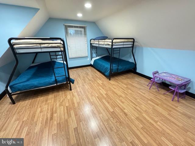 bedroom with light hardwood / wood-style flooring and lofted ceiling