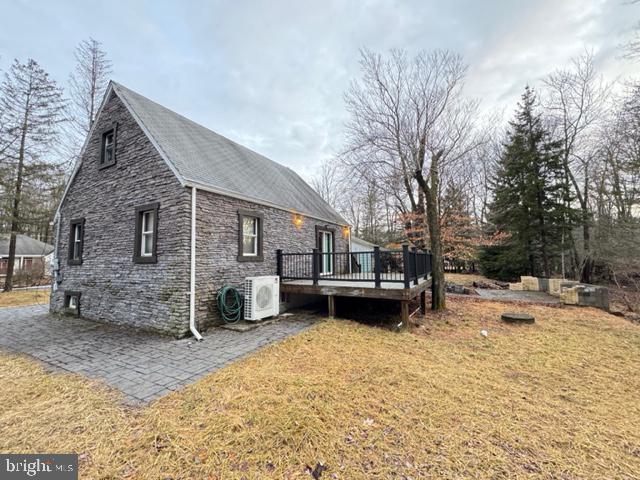 view of home's exterior with ac unit, a lawn, and a wooden deck