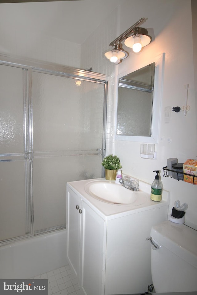 full bathroom with tile patterned flooring, combined bath / shower with glass door, toilet, and vanity