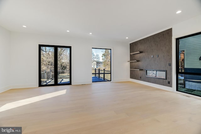 unfurnished living room featuring french doors and light hardwood / wood-style floors