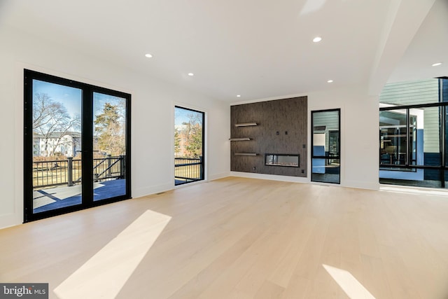 unfurnished living room featuring a fireplace and light hardwood / wood-style floors