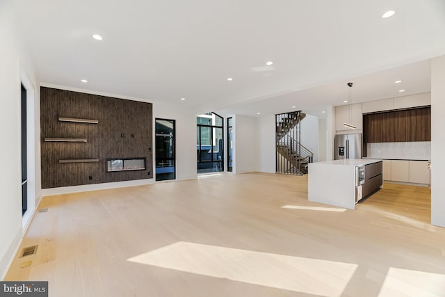 unfurnished living room with a fireplace and light wood-type flooring