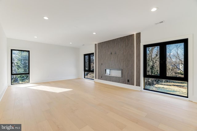 unfurnished living room with plenty of natural light and light hardwood / wood-style floors