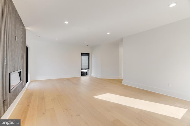 unfurnished room with a large fireplace and light hardwood / wood-style flooring