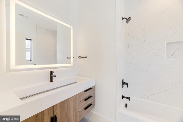 bathroom featuring vanity and tiled shower / bath