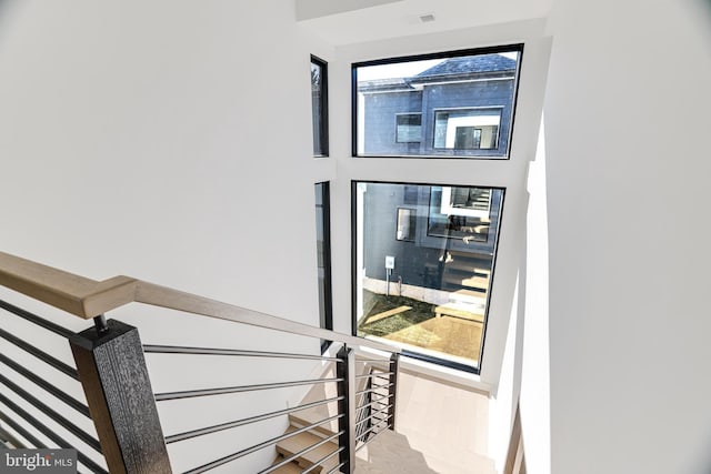 stairs featuring a healthy amount of sunlight and hardwood / wood-style floors