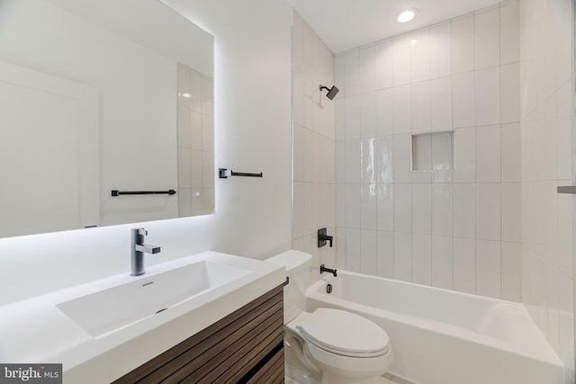 full bathroom featuring vanity, tiled shower / bath combo, and toilet