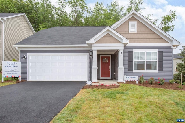 view of front of property featuring a front yard and a garage