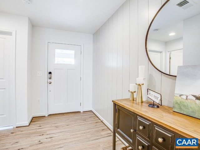 entryway featuring wood walls and light hardwood / wood-style flooring