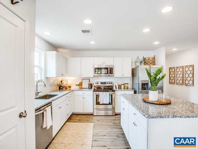 157 Lookover Ter, Stuarts Draft, VA 24477 - kitchen featuring stainless steel appliances, a sink, light wood-style floors, white cabinetry, and light stone countertops