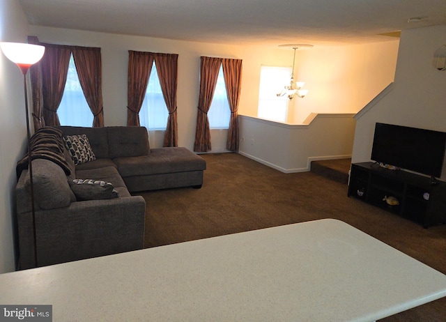 living room featuring dark colored carpet and an inviting chandelier