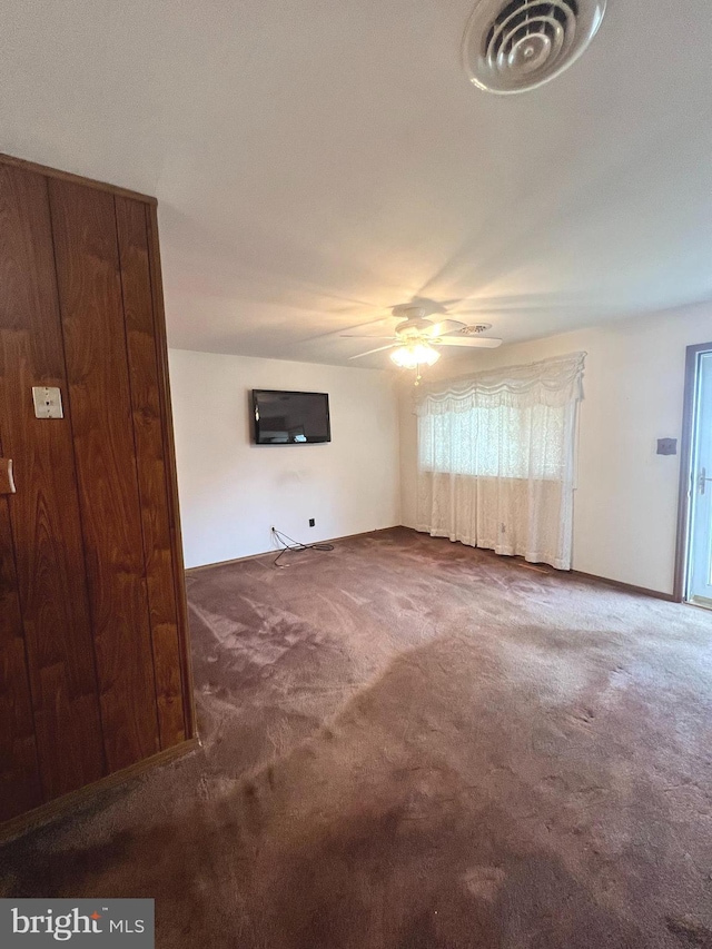 unfurnished living room featuring ceiling fan and carpet floors