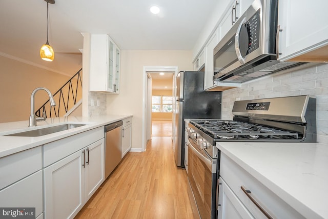 kitchen featuring white cabinets, sink, appliances with stainless steel finishes, and tasteful backsplash