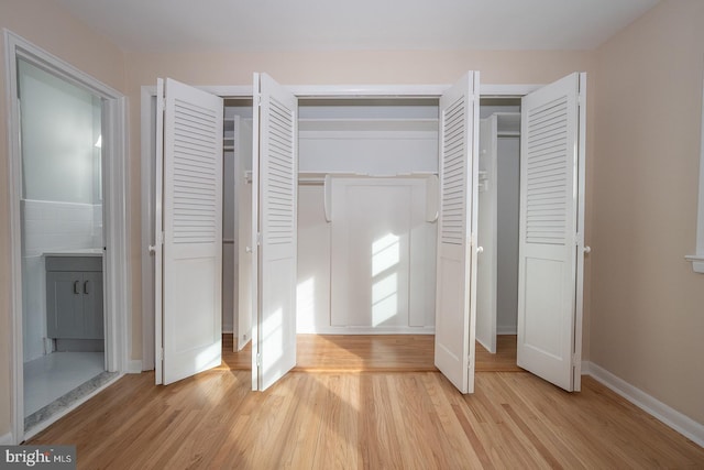 unfurnished bedroom featuring light hardwood / wood-style flooring and multiple closets