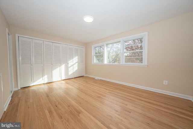 unfurnished bedroom with a closet and light hardwood / wood-style flooring