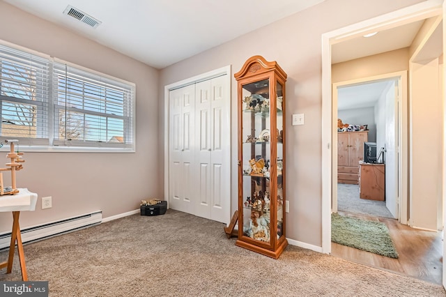 carpeted bedroom with a closet and a baseboard radiator