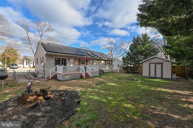 view of front of property featuring a front yard, solar panels, a storage unit, and a wooden deck