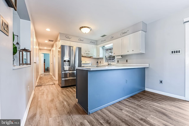 kitchen featuring kitchen peninsula, stainless steel refrigerator with ice dispenser, light hardwood / wood-style flooring, white cabinetry, and range