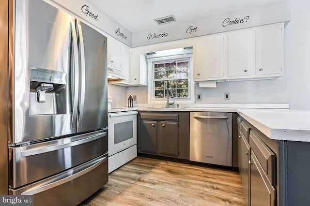 kitchen featuring white cabinets, stainless steel appliances, light hardwood / wood-style floors, and sink