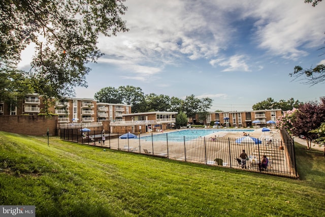 view of pool with a lawn and a patio