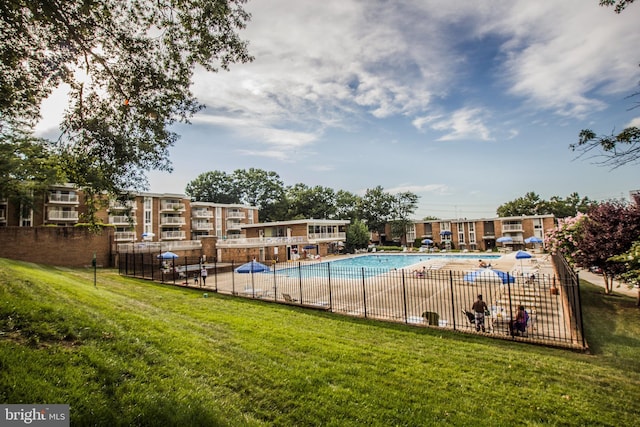 view of pool featuring a lawn and a patio area