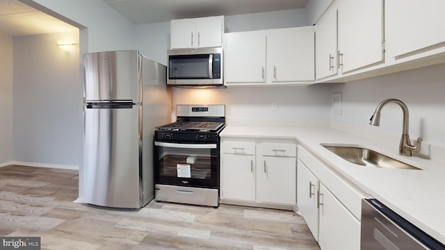 kitchen featuring sink, white cabinets, stainless steel appliances, and light hardwood / wood-style floors