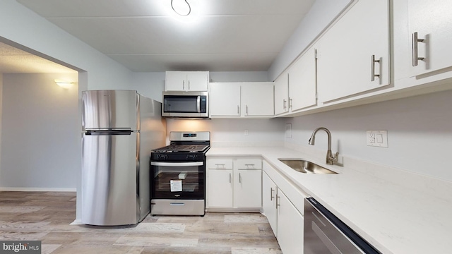 kitchen with light hardwood / wood-style floors, sink, white cabinetry, and stainless steel appliances